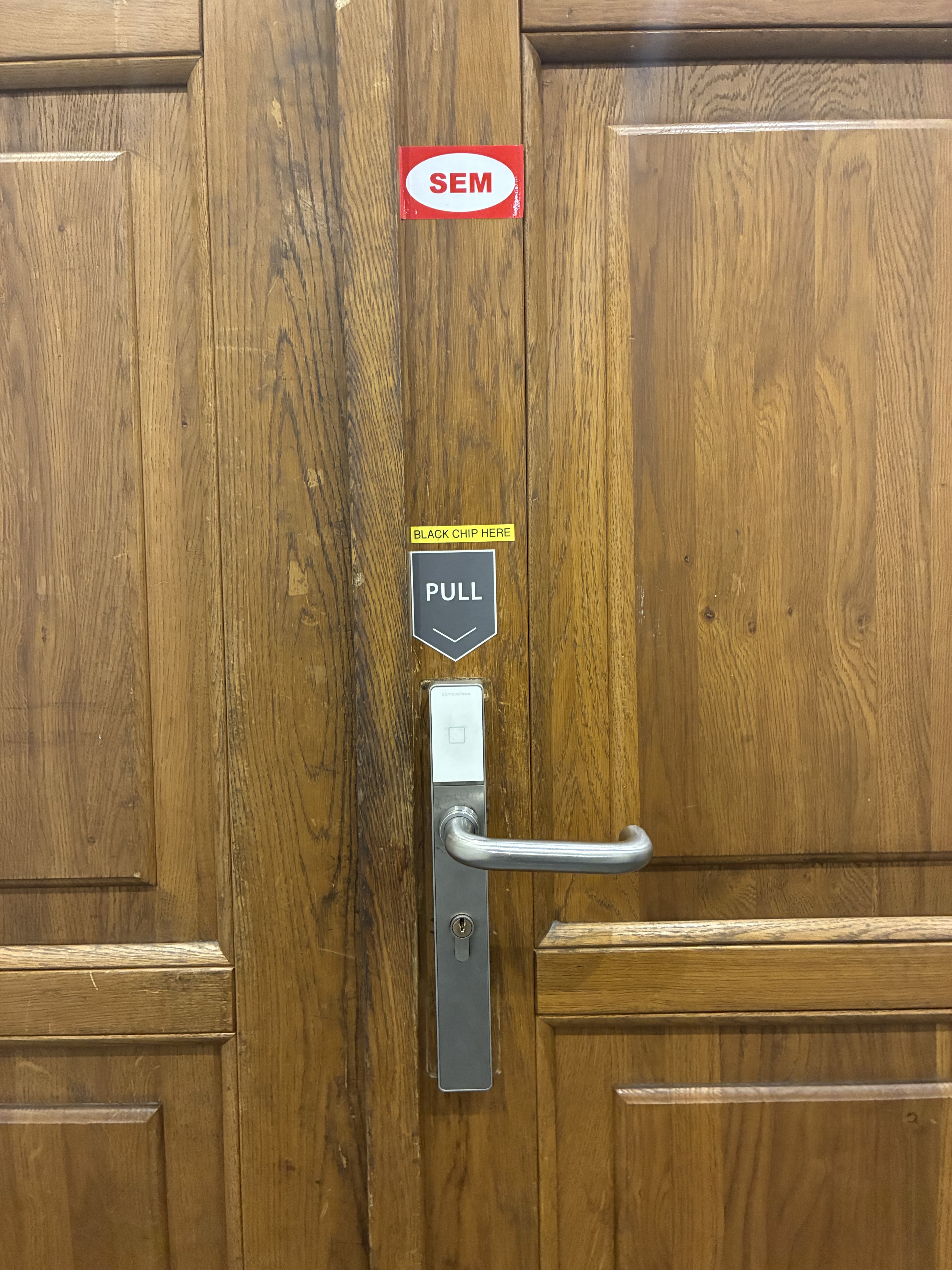 Main wooden entrance door of Hotel Melantrich with a white reader above the handle