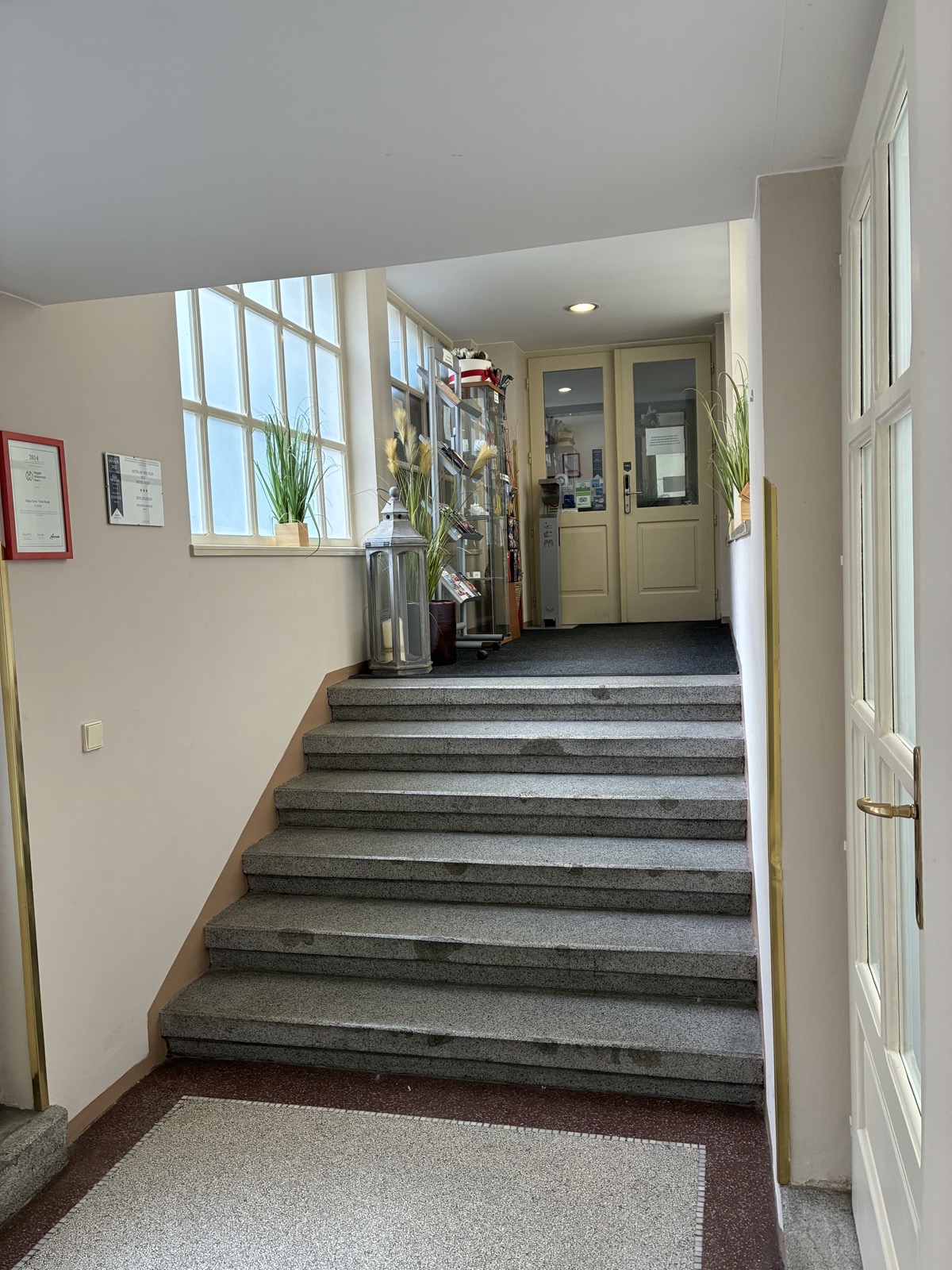 Corridor behind the white door leading towards reception